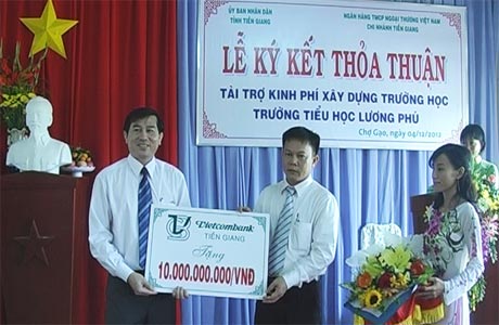 Ông Lê Văn Hưởng, Phó Chủ tịch UBND tỉnh nhận bảng tượng trưng tài trợ 10 tỷ đồng từ ông Nguyễn Quang Minh, Giám đốc Vietcombank.