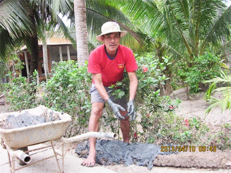 Chú Hai Soái đang đẩy đất ốp lề đường dal trong xóm.