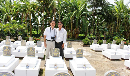 Thầy Nguyễn Mạnh Bình (bên phải) bên mộ đồng đội.