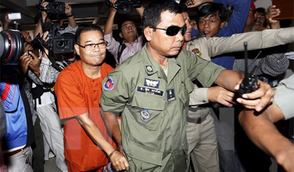 Cảnh sát áp giải ông Hong Sok Hour, thượng nghị sỹ đảng CNRP, tới tòa vì xuyên tạc tình hình biên giới với Việt Nam. Ảnh: Reuters/ TTXVN