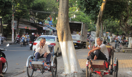 Bác Nguyễn Văn Hoàng (phải) và người bạn già đạp xích lô đang chờ khách.