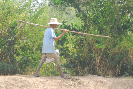 Chiều xuống, ông Nguyễn Văn Huệ, xã Mỹ Thành Bắc, huyện Cai Lậy vác cuốc về nhà sau một ngày làm việc cực nhọc.