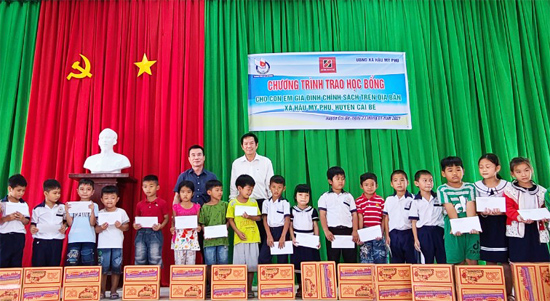Ông Trương Vân Đoàn -  Phó Giám đốc Agribank Tiền Giang (áo trắng) và Ông Dương Vũ Thông - Phó Chủ tịch Hội Nhà báo trao học bổng cho các cháu.