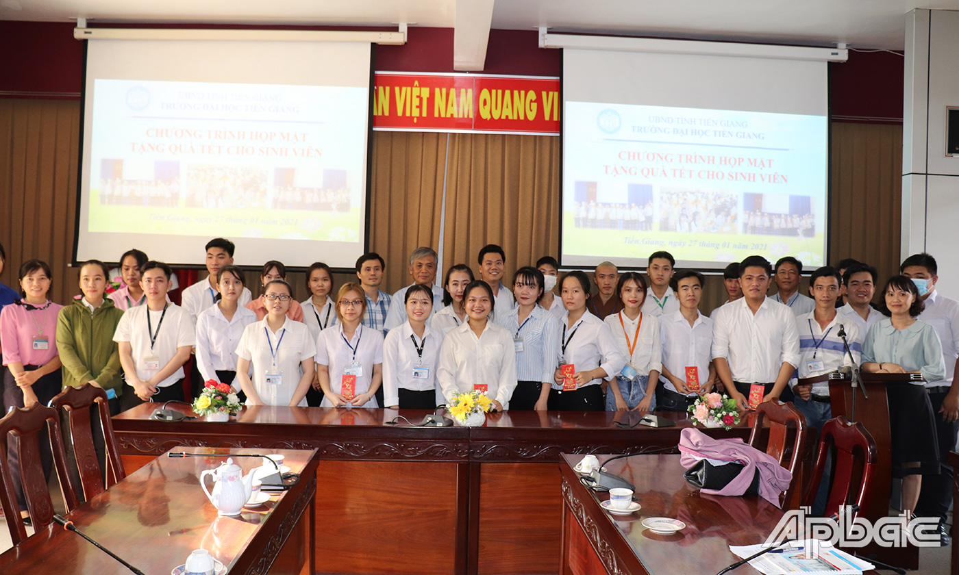 Các thầy cô chụp ảnh lưu niệm với các sinh viên được nhận quà tết.