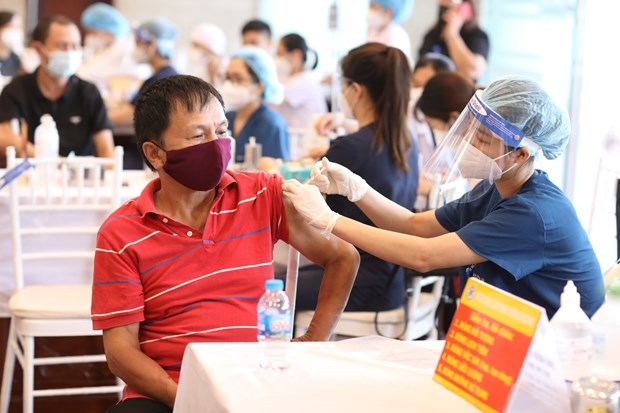 Nhân viên y tế tiêm vaccine phòng COVID-19 cho người dân quận Hoàn Kiếm. (Ảnh: Minh Quyết/TTXVN)