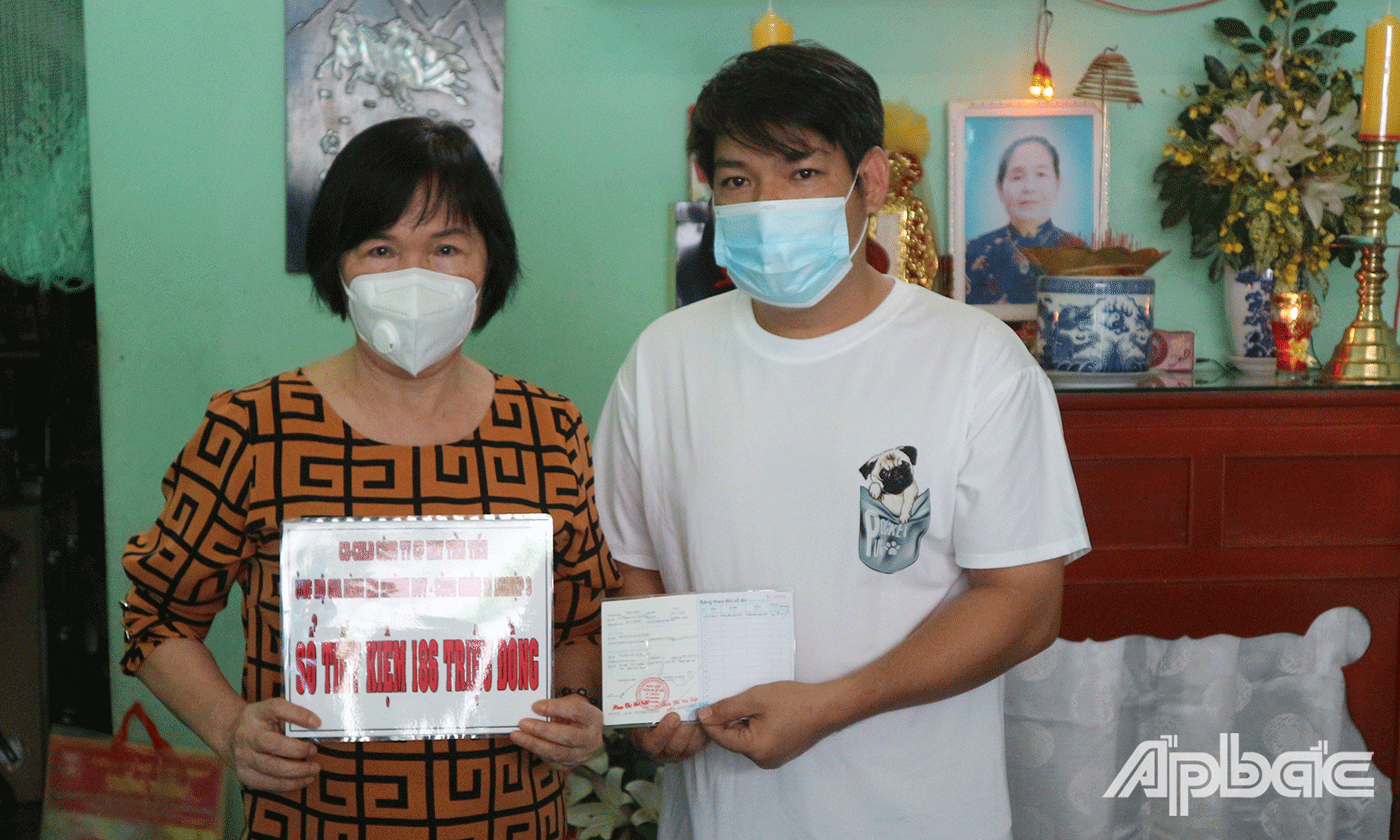 Bà Phạm Thị Dụ Tổng Giám đốc Công ty Cổ phần may Tiền Tiến  đại diện tập thể công nhân lao động công ty, trao sổ tiết kiệm trị giá 186 triệu đồng 