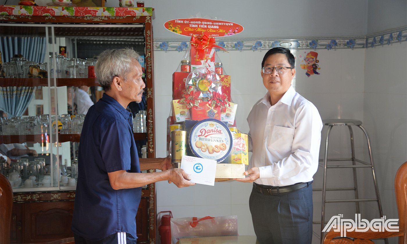 Đồng chí Trần Thanh Nguyên trao quà Thương binh Nguyễn Kim Quang ấp Bình Hưng, xã Thành Công.