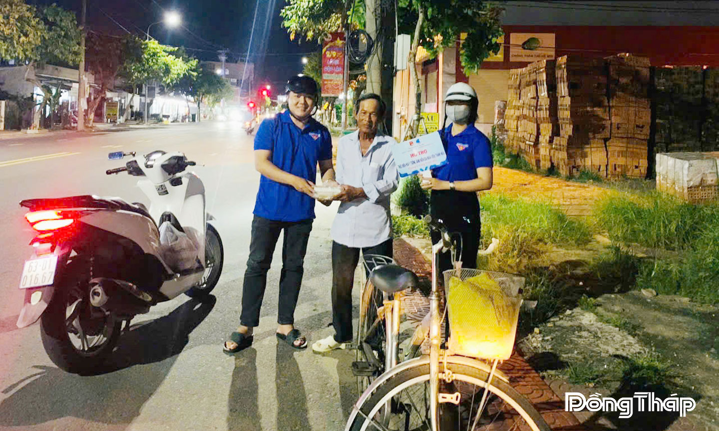 Người dân ở phường Sa Đéc nhận các suất điểm tâm và quà do anh  Ngô Văn Quí tặng.