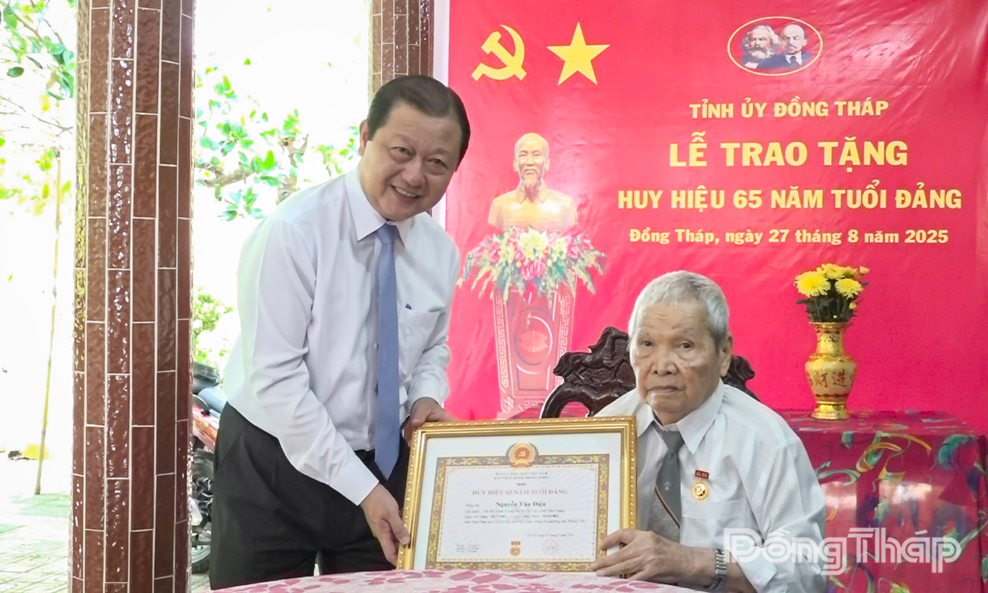 Đồng chí Phan Phùng Phú trao Huy hiệu 65 năm tuổi Đảng cho Đại tá, Anh hùng Lực lượng Vũ trang nhân dân Nguyễn Văn Điện.
