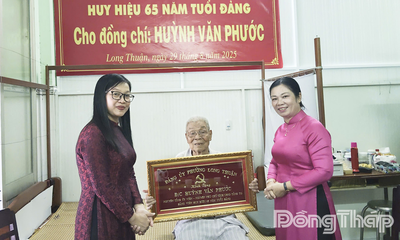 Đồng chí Nguyễn Thị Kim Tuyến, Ủy viên Ban Thường vụ Tỉnh ủy, Trưởng Ban Tuyên giáo và Dân vận Tỉnh ủy; cùng đồng chí Lê Thị Đẩu, Bí thư Đảng ủy, Chủ tịch HĐND phường Long Thuận trao tặng Huy hiệu 65 năm tuổi Đảng và bức Khánh của Ban Thường vụ Tỉnh ủy, bức Khánh của Đảng ủy phường Long Thuận.