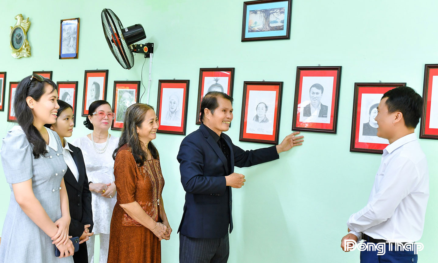 Nghệ sĩ Minh Đức giới thiệu các chân dung văn nghệ sĩ tại triển lãm.