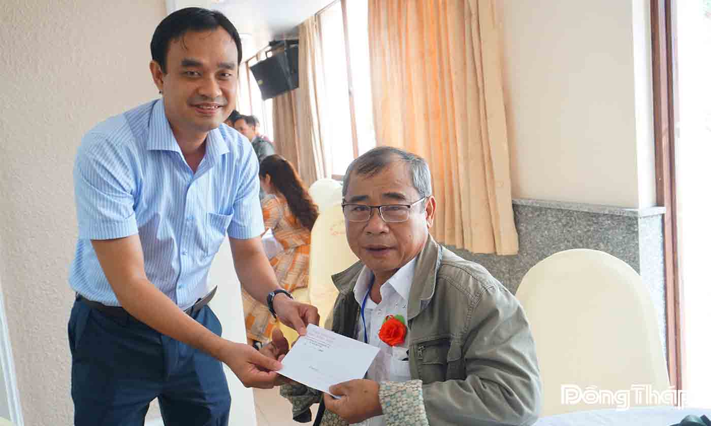 Đồng chí Nguyễn Văn Vũ Minh, Giám đốc Sở Nội vụ tỉnh Đồng Tháp cài hoa và tặng quà cho người có công trước khi tham quan thủ đô Hà Nội.