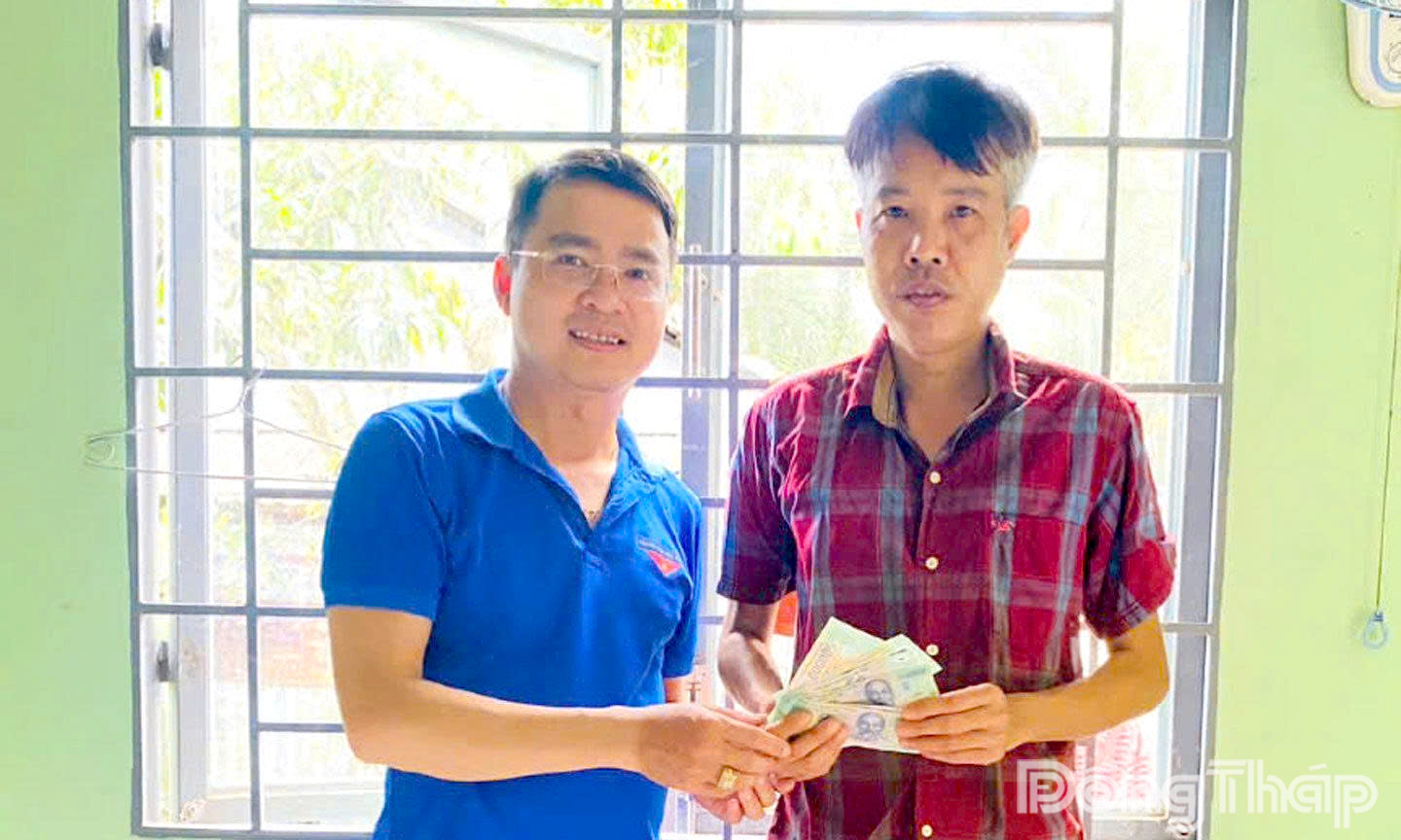 Tiến sĩ Võ Văn Sơn, giảng viên Trường Đại học Tiền Giang trao tiền hỗ trợ anh Lê Quốc Chỉnh.