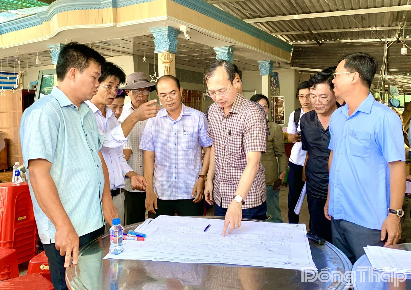 Chủ tịch Ủy ban nhân dân tỉnh Đồng Tháp Trần Trí Quang xem biểu đồ thể hiện độ sâu, diện tích sạt lở, lượng nước, vùng hố xoáy tại khu vực sạt lở bờ sông Tiền.