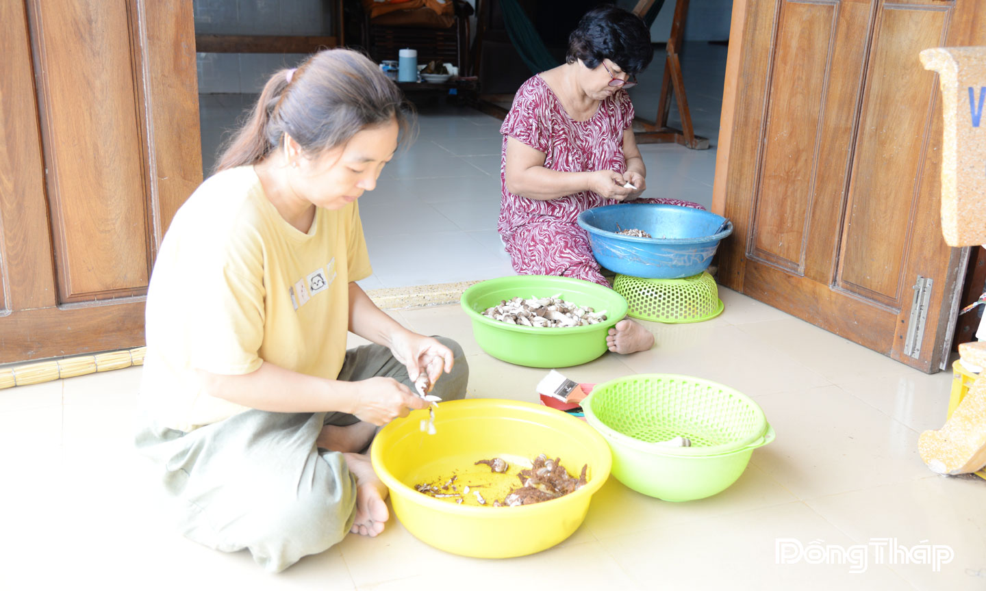 Chị An (bìa trái) gọt, vệ sinh nấm mối đen chuẩn bị giao cho khách hàng.