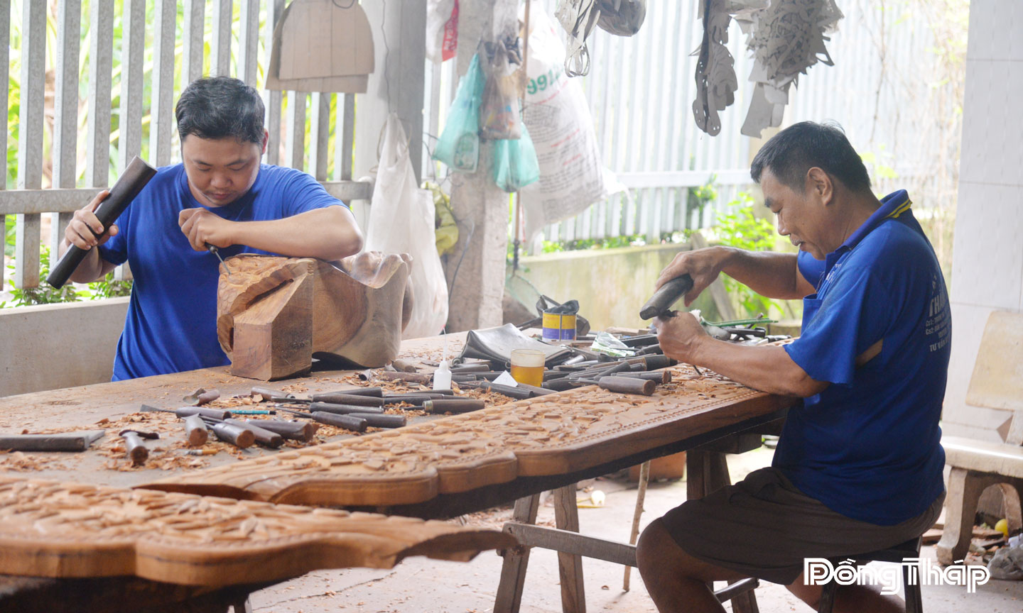 Nghệ nhân Lê Văn Hùng (Cơ sở chạm Ba Nữ) và anh Lê Minh Quân đang cần mẫn tạo ra những tác phẩm độc đáo.