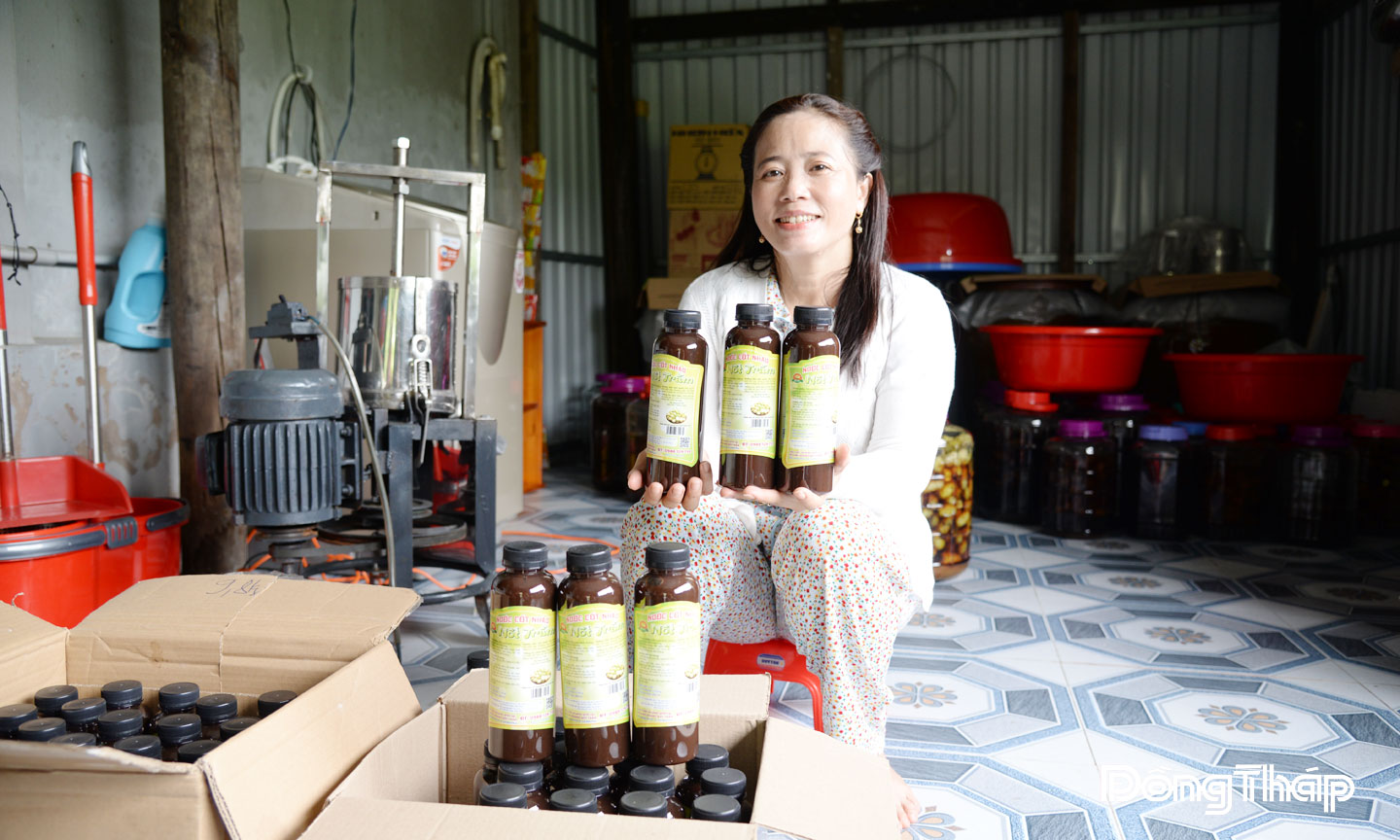 Chị Thu bên sản phẩm nước cốt nhàu do mình sản xuất.