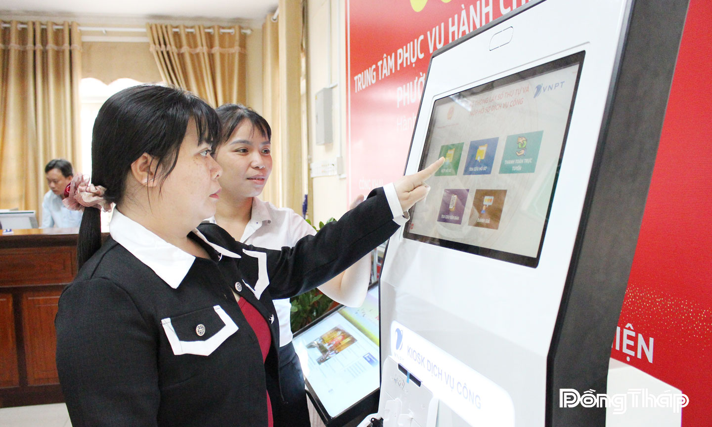 Công chức Trung tâm Phục vụ hành chính công phường Sa Đéc (tỉnh Đồng Tháp) hướng dẫn người dân nộp hồ sơ trực tuyến tại ki-ốt thông minh.