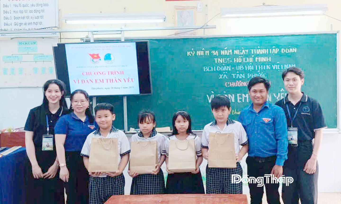 Anh Danh Hoài Hận (thứ 2 từ phải sang) tặng quà cho học sinh  có hoàn cảnh khó khăn trên địa bàn xã Tân Đông.