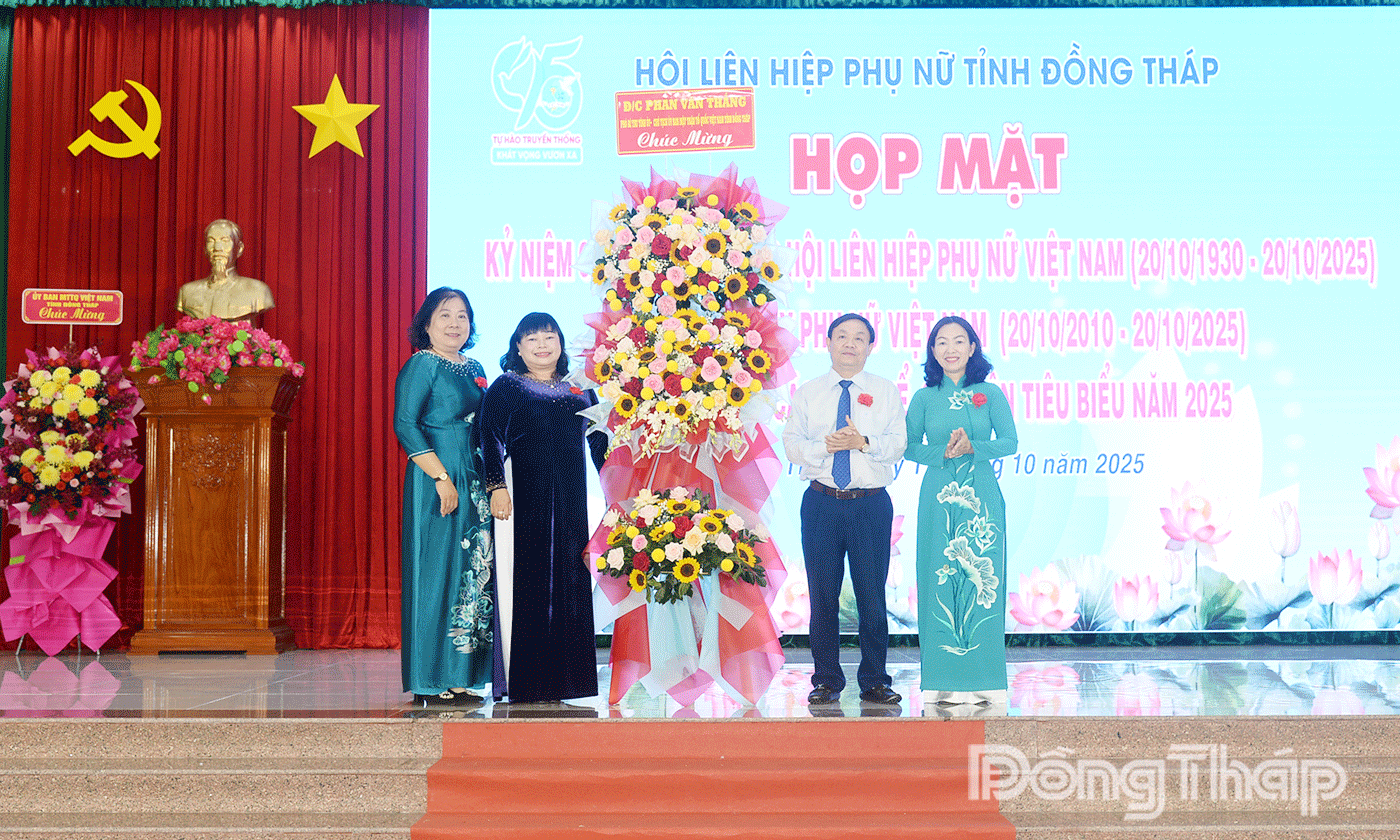 Đồng chí Phan Văn Thắng, Phó Bí thư Tỉnh ủy tặng hoa chúc mừng tại buổi họp mặt.