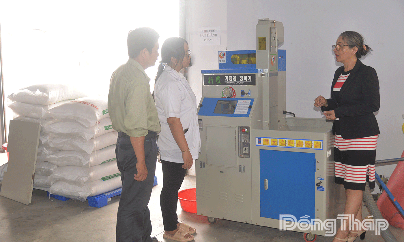 Bà Hồ Lan Anh (bên phải), Phó Giám đốc Công ty TNHH Thương mại HK kiểm tra máy xát gạo..