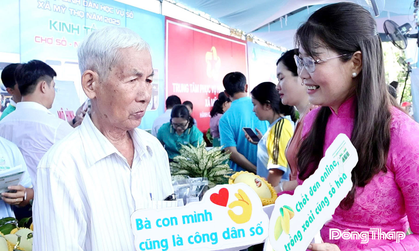 Bí thư Đảng ủy xã Mỹ Thọ Phạm Thị Ngọc Đào trao đổi với nông dân  về quy trình bán xoài hữu cơ qua mạng.   	                               Ảnh: Thúy Nhi