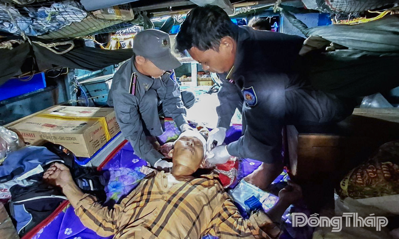 Tổ y tế tiến hành sơ cứu, băng bó viết thương cho ngư dân gặp nạn.
