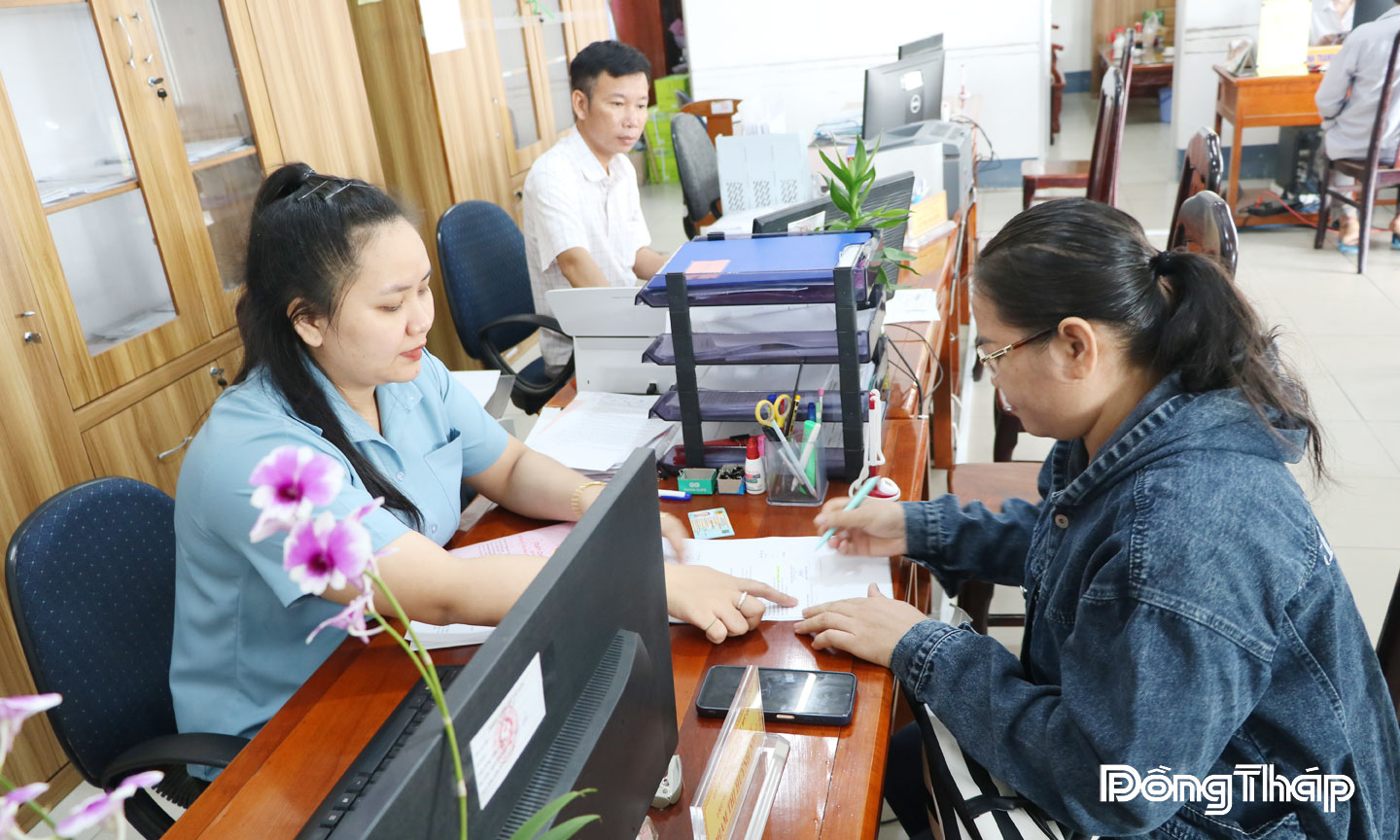 Cán bộ Trung tâm Phục vụ hành chính công xã Mỹ Quí hướng dẫn người dân thực hiện thủ tục hành chính.