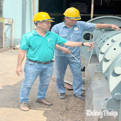 Anh Nguyễn Bá Châu  (bên trái) trao đổi với đồng nghiệp về bảo trì vận hành thiết bị tại công ty.
