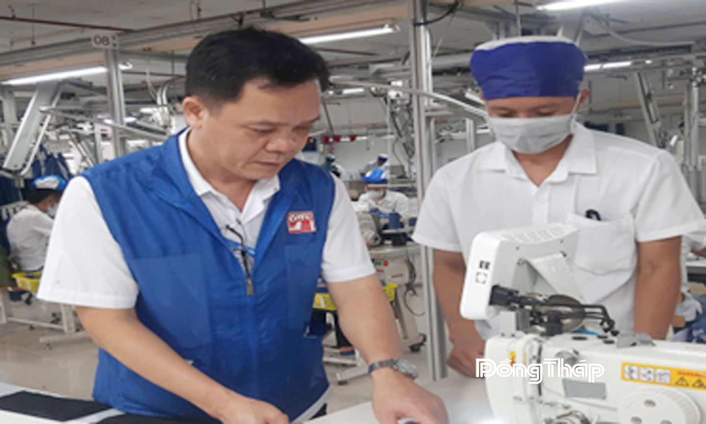 Anh Phan Văn Vĩ (bên trái) hướng dẫn kỹ thuật cắt may cho công nhân mới vào nghề.