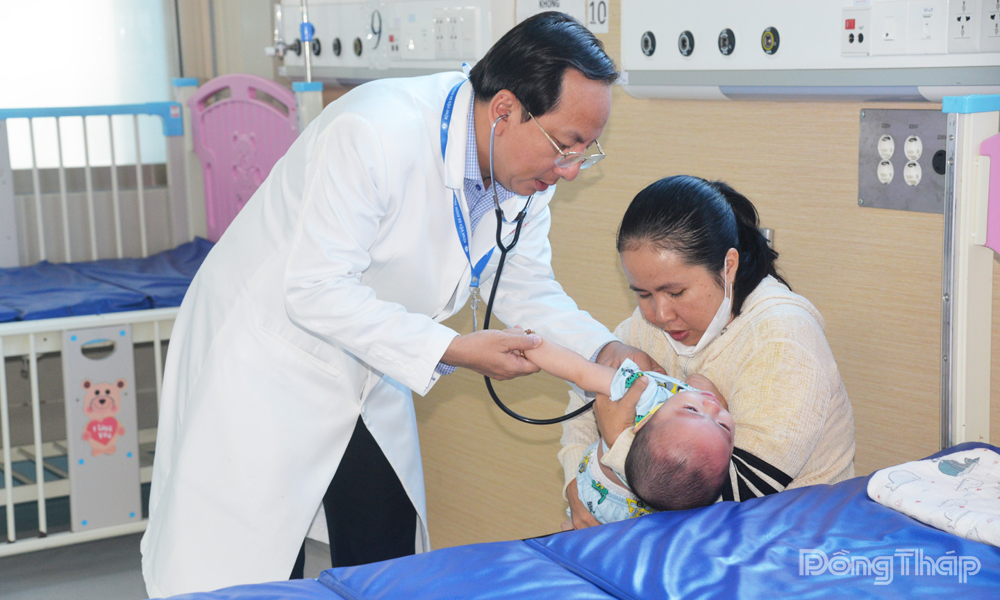 Tiến sĩ bác sĩ Đỗ Quang Thành, Phó Giám đốc Bệnh viện đa khoa Tiền Giang thăm khám cho bệnh nhi mắc sốt xuất huyết đang điều trị tại Khoa hồi sức tích cực chống độc nhi. Ảnh: THỦY HÀ