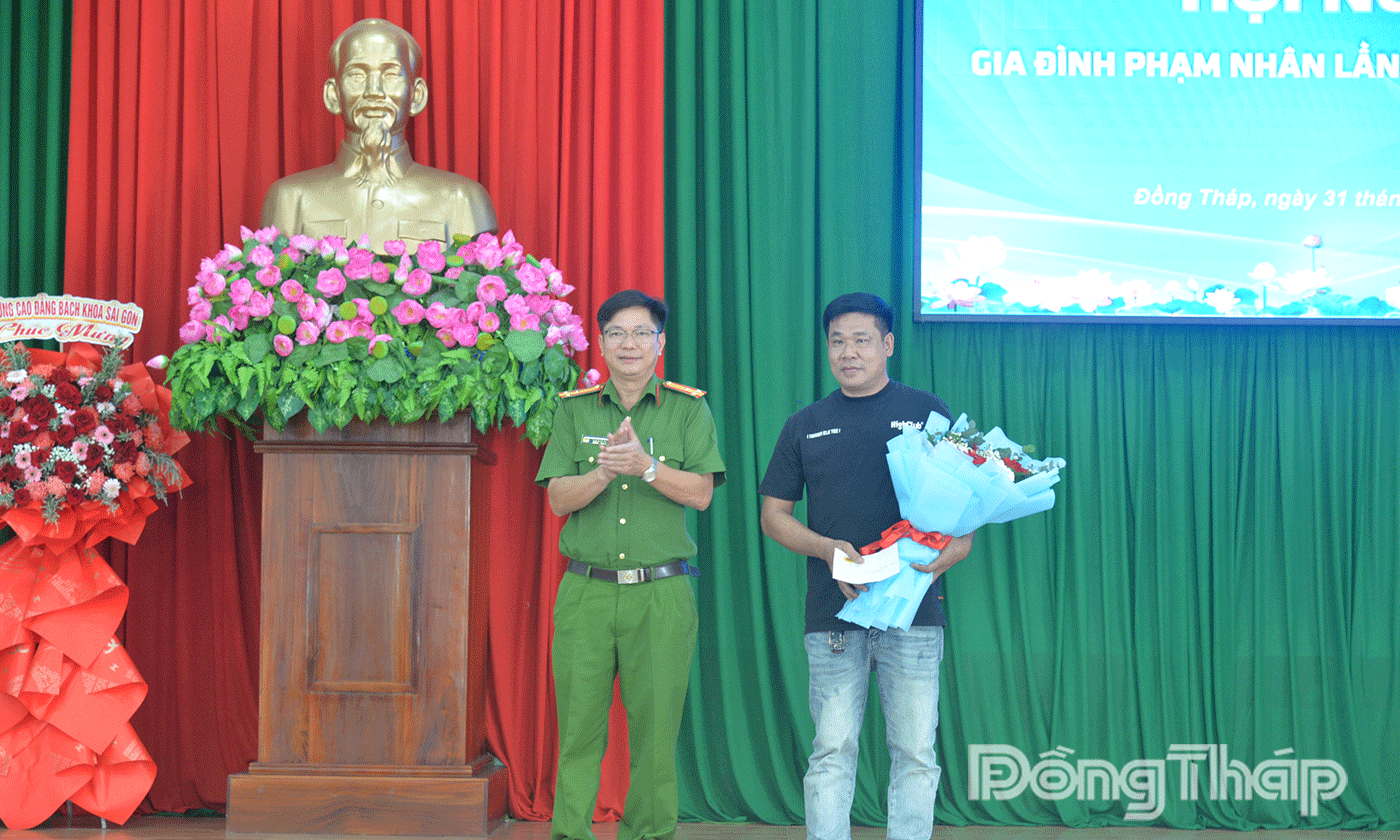 Thượng tá Vũ Văn Phượng, Phó Giám thị Trại giam Phước Hòa tặng hoa cho gia đình phạm nhân và người tái hòa nhập cộng đồng, vươn lên làm ăn, phát triển kinh tế gia đình 