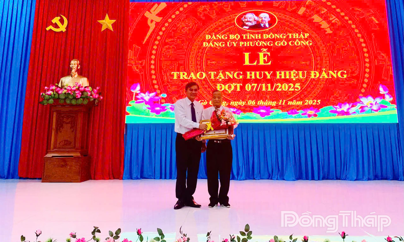 Đồng chí Nguyễn Văn Mười trao Huy hiệu Đảng cho đảng viên.