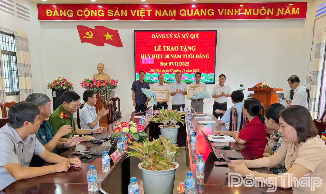 Bí thư Đảng ủy xã Mỹ Quí Phạm Việt Kiên trao tặng Huy hiệu Đảng cho các đảng viên.