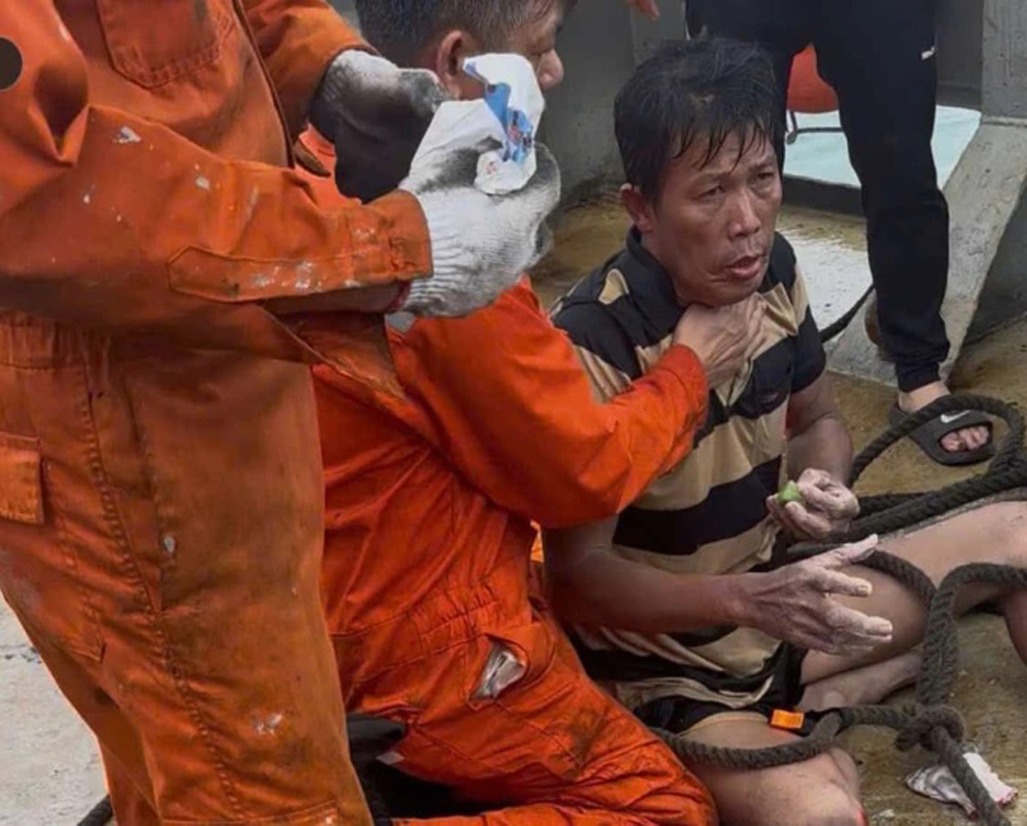 Ông Phạm Duy Quang (áo thun sọc) được các thuyền viên trên tàu Hải Nam 39 ứng cứu. Ảnh: Thuyền viên tàu Hải Nam 39 cung cấp