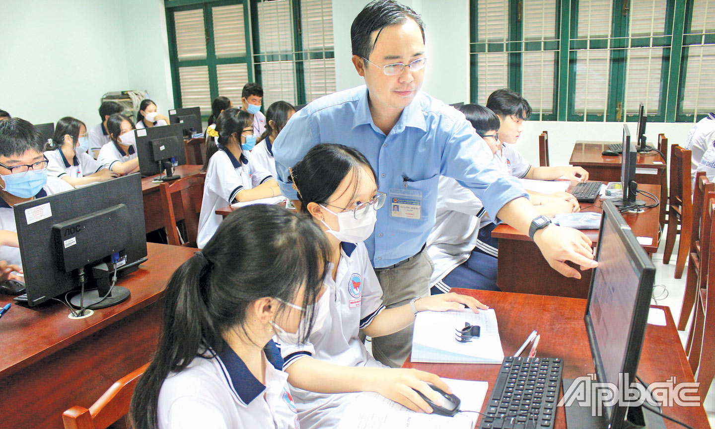 Giáo viên hỗ trợ học sinh thao tác thực hành trên máy vi tính tại Trường THPT Nguyễn Đình Chiểu (TP. Mỹ Tho). Ảnh: Sửu Minh