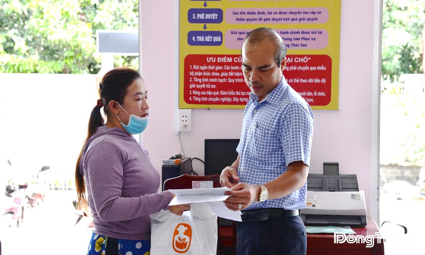 Lãnh đạo Trung tâm Phục vụ hành chính công phường Thới Sơn trực tiếp hỗ trợ người dân đến làm thủ tục hành chính. Ảnh: THÙY TRANG