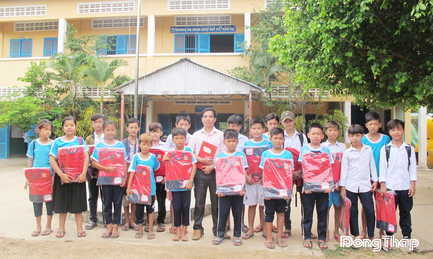 Thầy Nguyễn Văn Hào tặng quà cho học sinh là con em cộng đồng người Việt ở Campuchia.